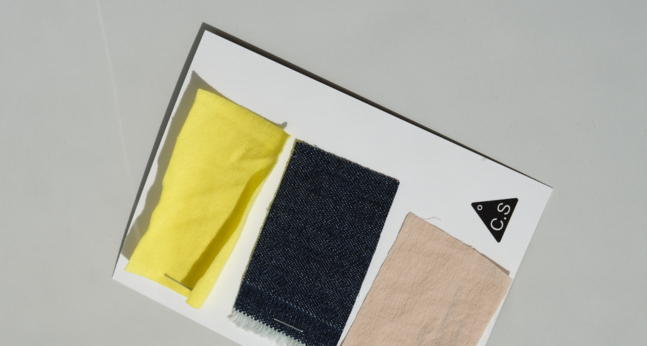 Small fabric swatches arranged on a table for textile sourcing
